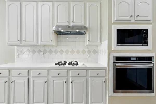 a kitchen with granite countertop white cabinets and stainless steel appliances