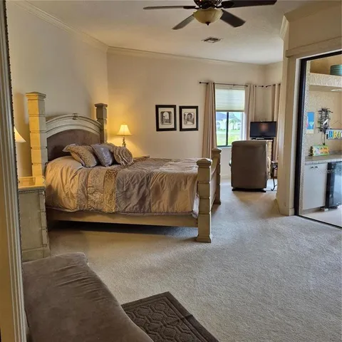 a spacious bedroom with a bed and glass walk in closet