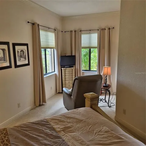 a bedroom with a bed and large windows