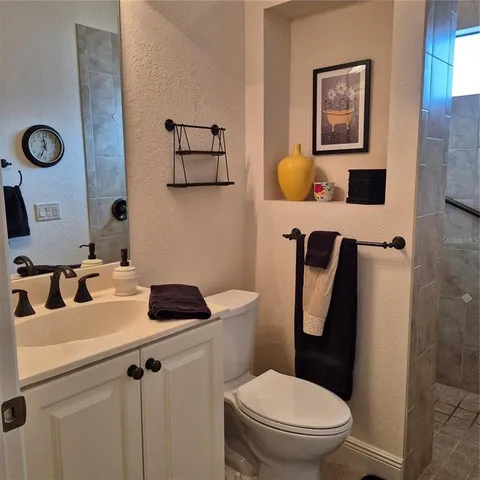 a bathroom with a toilet sink vanity and mirror