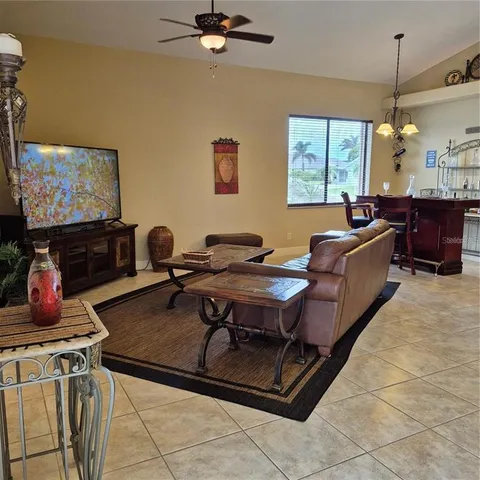 a living room with furniture a flat screen tv and a table
