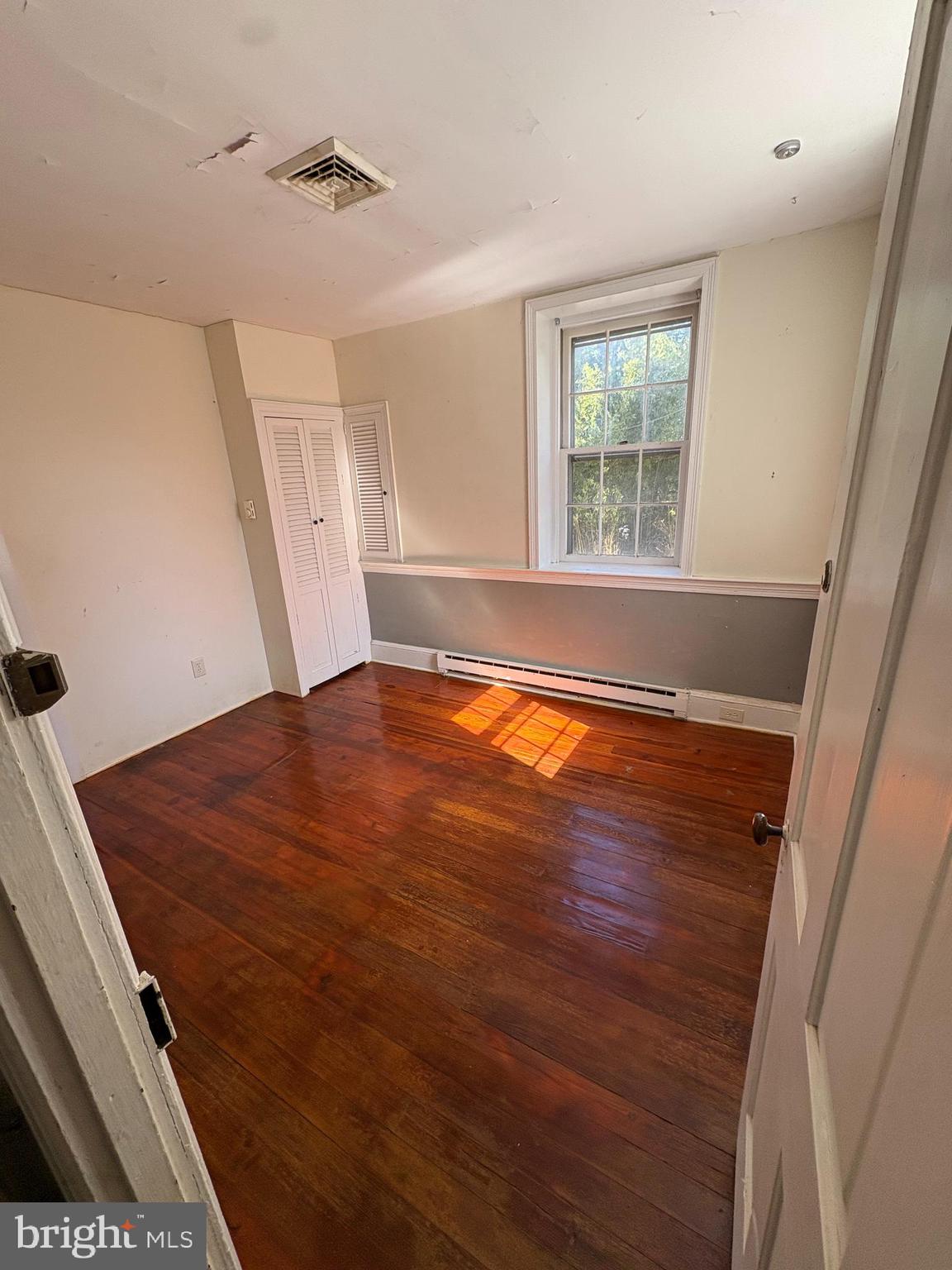 432 Quarry Road Ottsville, PA 18942 - Photo 10 of 29 a view of an empty room with wooden floor and a window