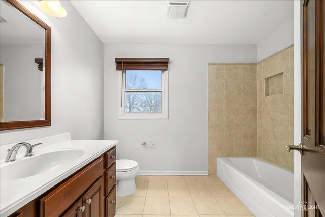 a bathroom with a granite countertop sink a toilet and bathtub