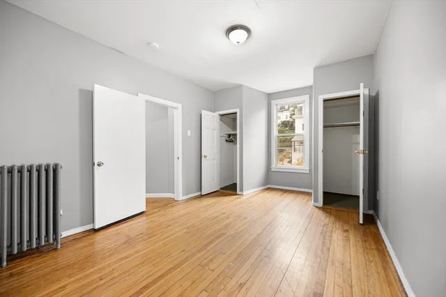 an empty room with wooden floor and a window