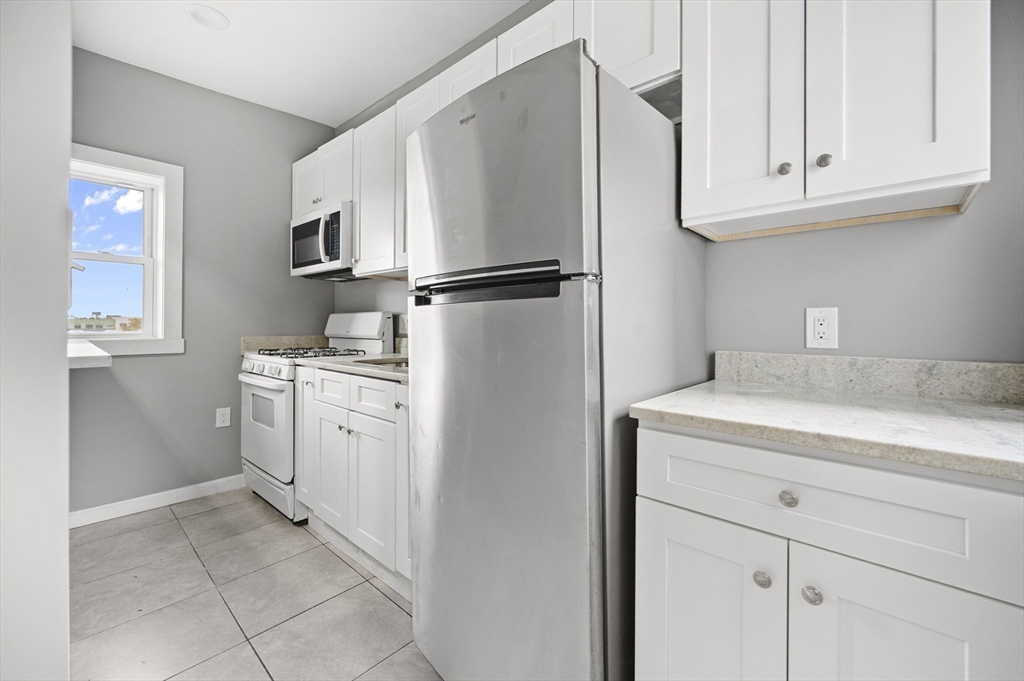 276 Washington Avenue, Unit 2 Chelsea, MA 02150 - Photo 6 of 28 a kitchen with cabinets and a refrigerator