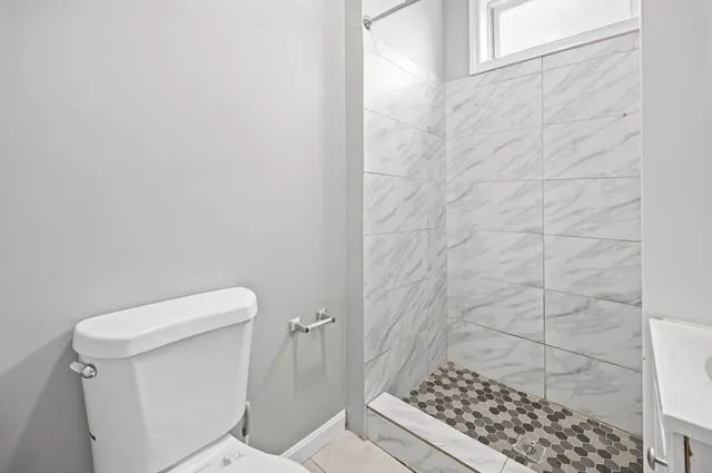 a bathroom with a toilet and a shower