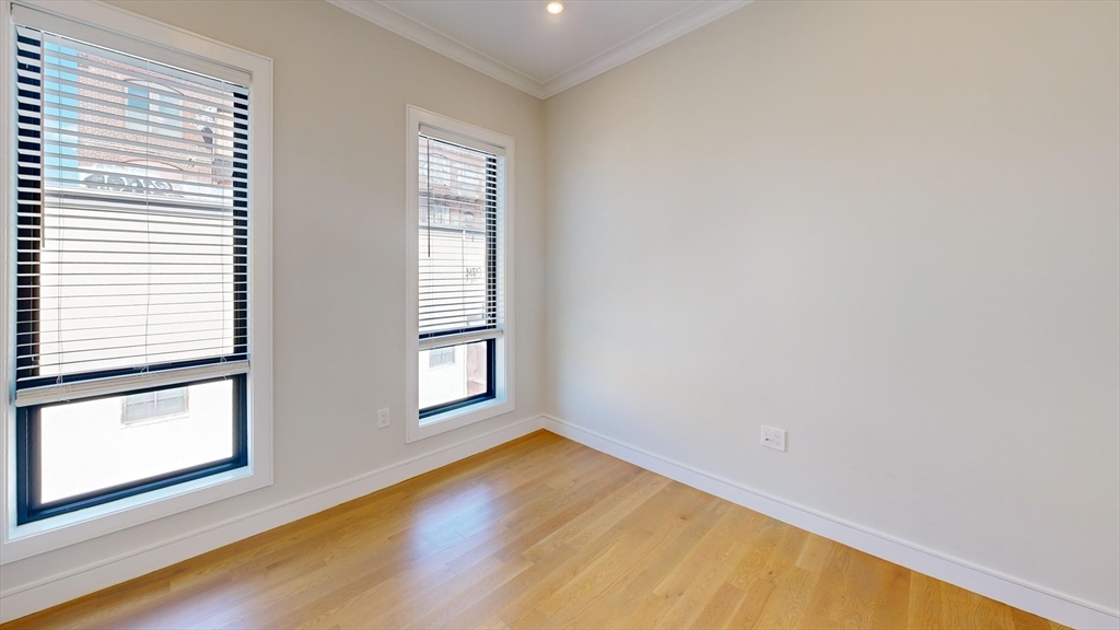 16-18 Highgate Street, Unit 202 Boston, MA 02134 - Photo 7 of 14 an empty room with wooden floor and windows