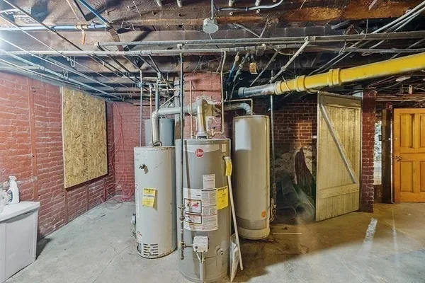 a view of a storage room with water heater and racks on the wall