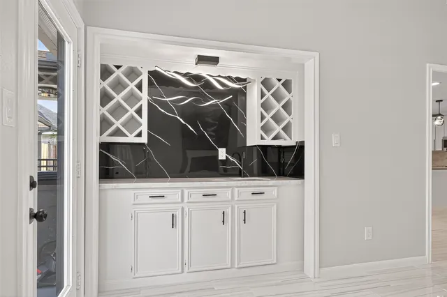 a large kitchen with kitchen island white cabinets and stainless steel appliances