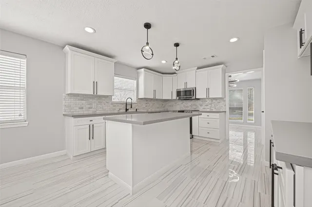 a kitchen with granite countertop white cabinets and white appliances