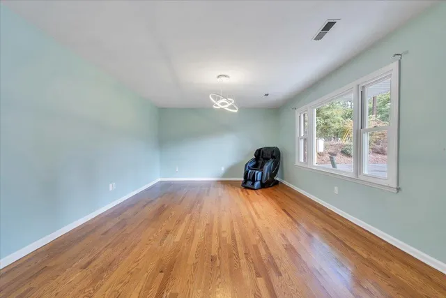 a view of a room with wooden floor air conditioner and windows