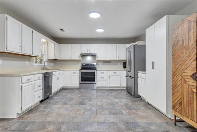 a view of a kitchen with a sink refrigerator and a window