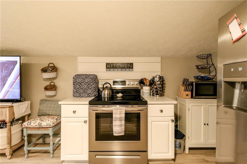 1155 Orchid Way Canton, GA 30115 - Photo 26 of 40 a kitchen with stainless steel appliances a stove a microwave and white cabinets