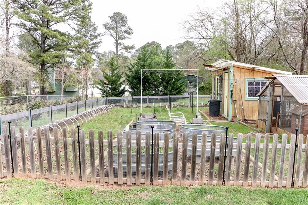 1155 Orchid Way Canton, GA 30115 - Photo 36 of 40 a view of a white house with a small yard and wooden fence