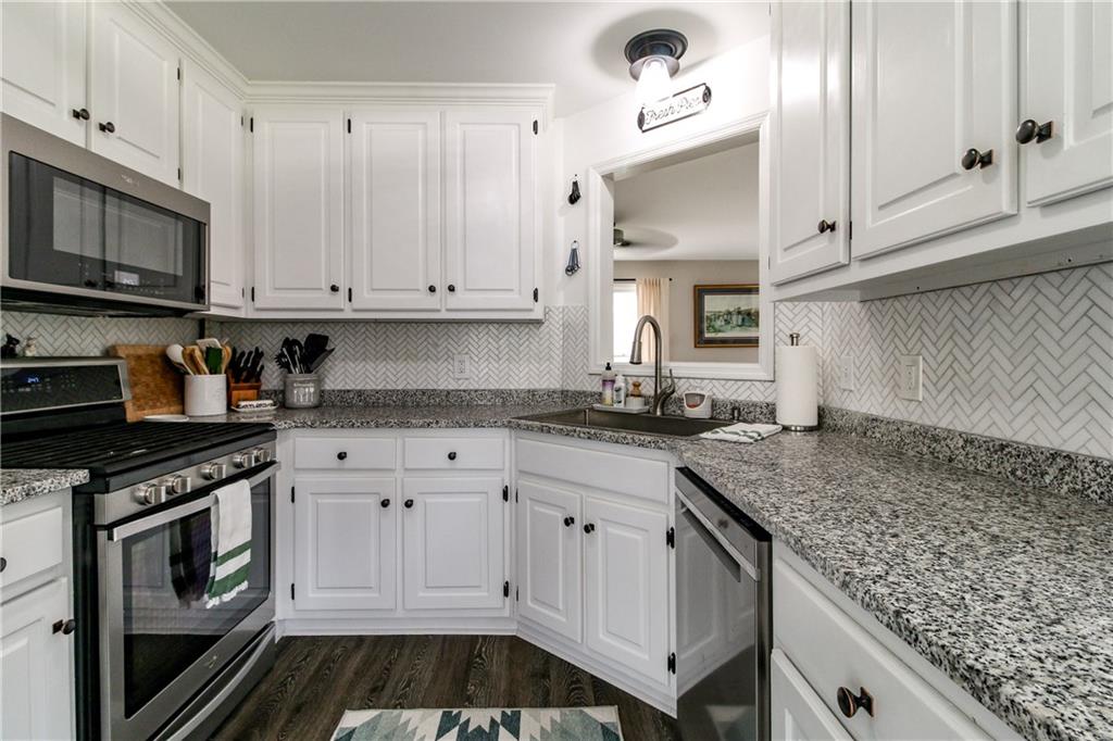 1155 Orchid Way Canton, GA 30115 - Photo 8 of 40 a kitchen with granite countertop a stove sink and cabinets