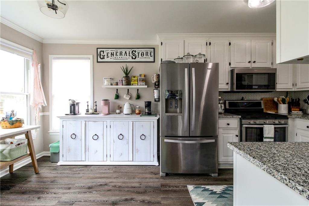 1155 Orchid Way Canton, GA 30115 - Photo 9 of 40 a kitchen with stainless steel appliances granite countertop a refrigerator stove and sink