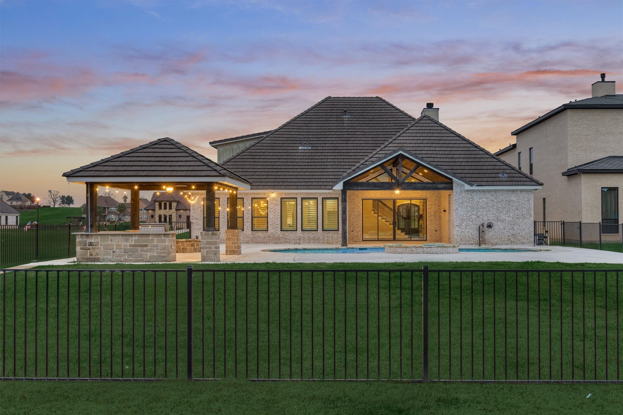 11618 Renaissance Drive Montgomery, TX 77356 - Photo 2 of 49 The back view of the home shows the covered back porch with its vaulted ceiling, a beautifully designed outdoor kitchen that complements the home’s finishes, and a fenced pool area offering added peace of mind for children and pets.