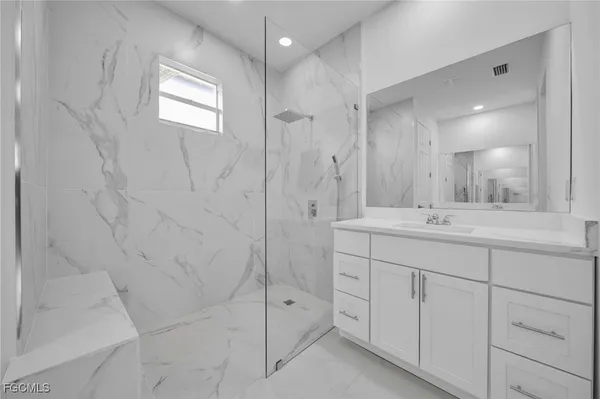 a bathroom with a shower sink and mirror