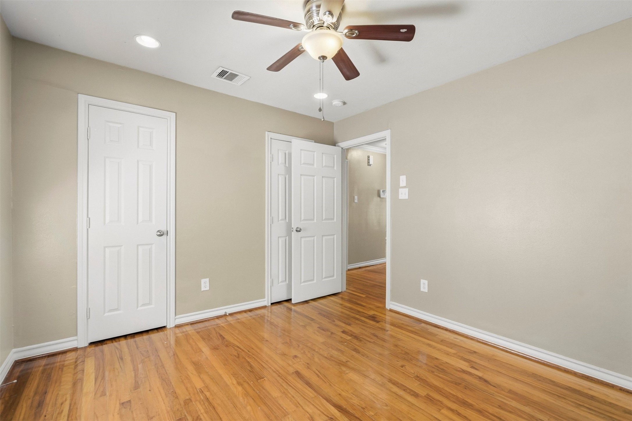 3445 Nathaniel Brown Street Houston, TX 77021 - Photo 16 of 19 an empty room with wooden floor and ceiling fan