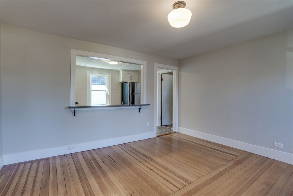 31 High Street, Unit 2 Beverly, MA 01915 - Photo 12 of 27 an empty room with wooden floor and windows