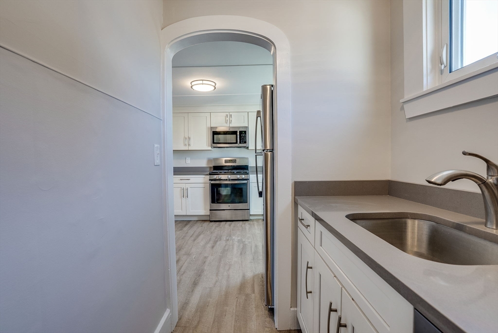 31 High Street, Unit 2 Beverly, MA 01915 - Photo 6 of 27 a kitchen with a sink cabinets and stainless steel appliances