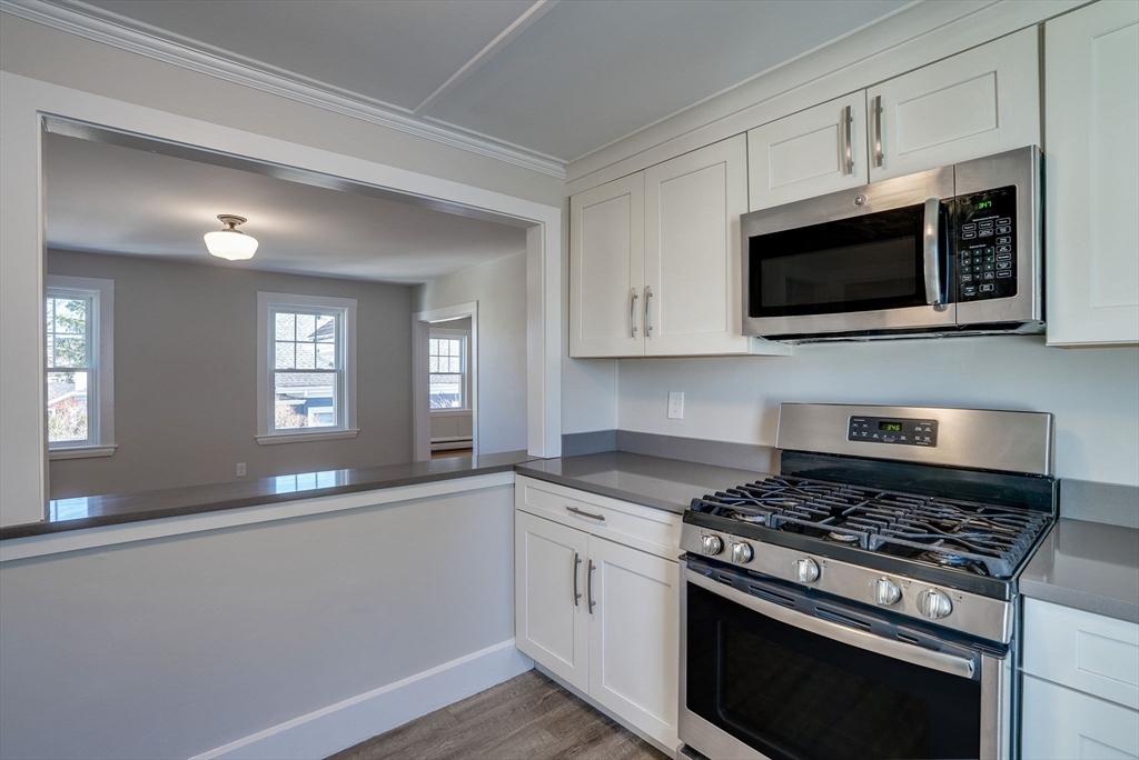 31 High Street, Unit 2 Beverly, MA 01915 - Photo 8 of 27 a kitchen with stainless steel appliances a stove a microwave and cabinets