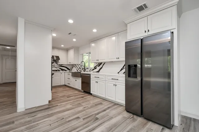 a kitchen with refrigerator a sink and a counter top space