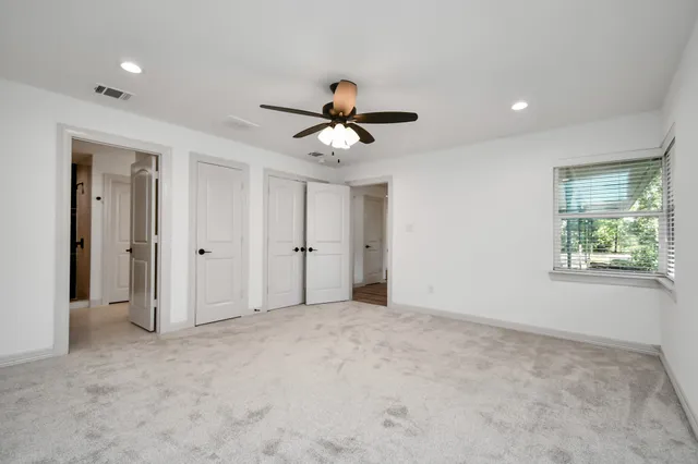 a view of a room with a ceiling fan and window