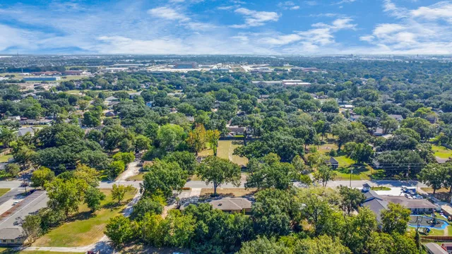 an aerial view of residential houses with outdoor space and trees