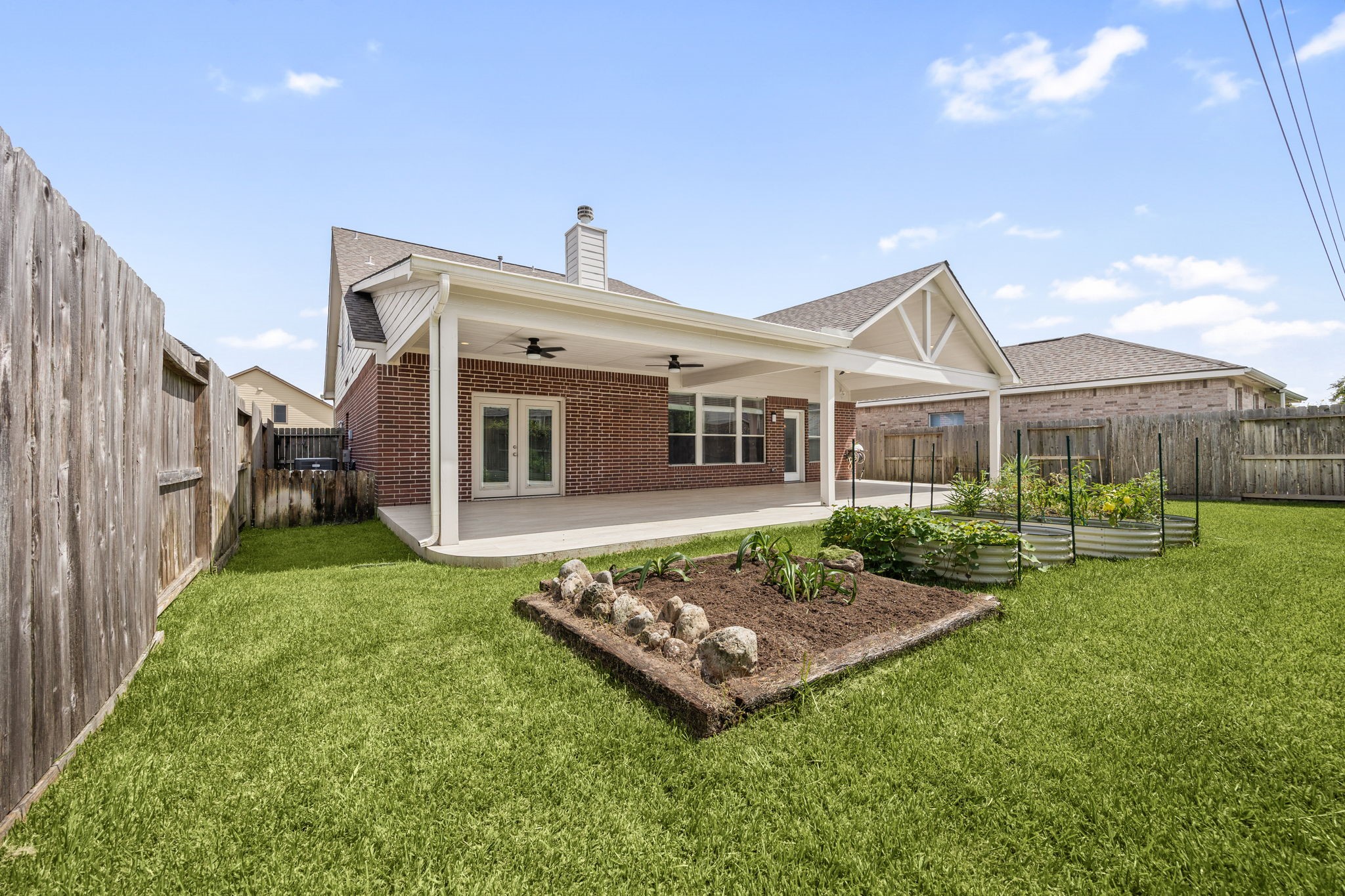 4526 Countrypines Drive Spring, TX 77388 - Photo 35 of 38 Fully fenced backyard featuring custom bordered garden beds, multi-tier raised garden boxes, and a massive covered patio.