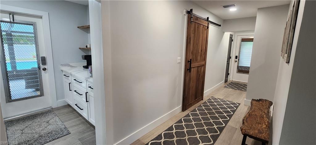 1280 Morningside Drive Naples, FL 34103 - Photo 11 of 35 a view of hallway with walk in closet and wooden floor