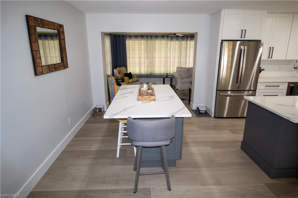 1280 Morningside Drive Naples, FL 34103 - Photo 12 of 35 a kitchen with stainless steel appliances granite countertop a refrigerator a stove a sink dishwasher and a refrigerator with wooden floor
