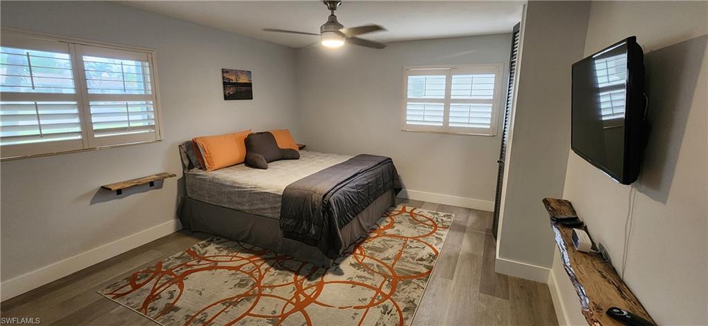 1280 Morningside Drive Naples, FL 34103 - Photo 15 of 35 a bedroom with a bed and large windows