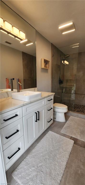 1280 Morningside Drive Naples, FL 34103 - Photo 16 of 35 a bathroom with a double vanity sink a toilet and a mirror