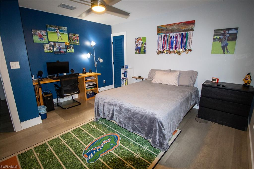 1280 Morningside Drive Naples, FL 34103 - Photo 20 of 35 a bedroom with a bed and a chandelier