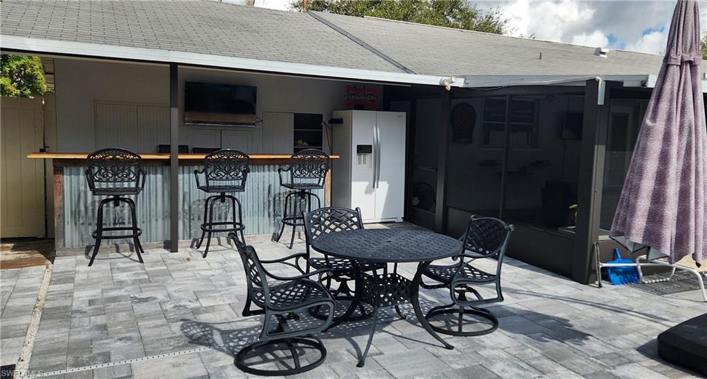 1280 Morningside Drive Naples, FL 34103 - Photo 31 of 35 a patio with table and chairs and potted plants