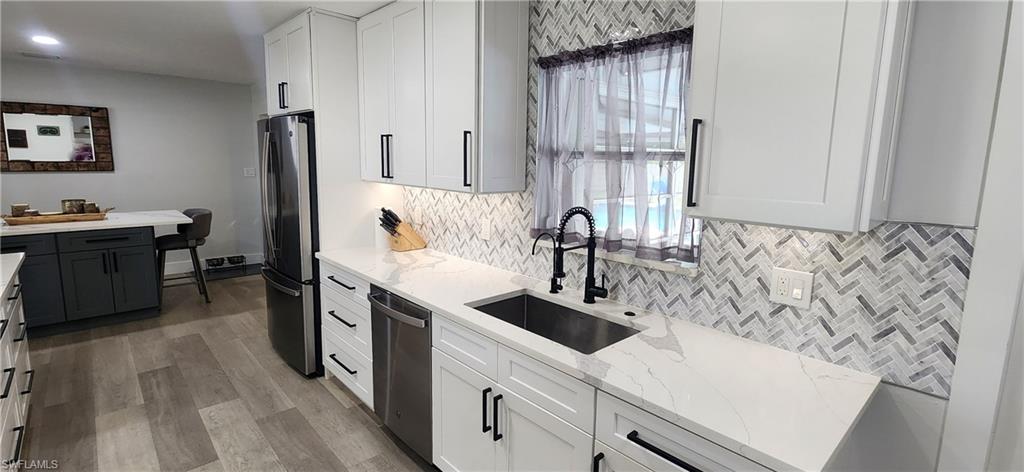 1280 Morningside Drive Naples, FL 34103 - Photo 7 of 35 a kitchen with stainless steel appliances granite countertop a sink stove and refrigerator
