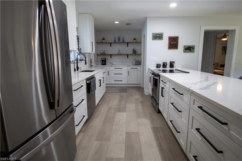 1280 Morningside Drive Naples, FL 34103 - Photo 8 of 35 a kitchen with white cabinets and appliances