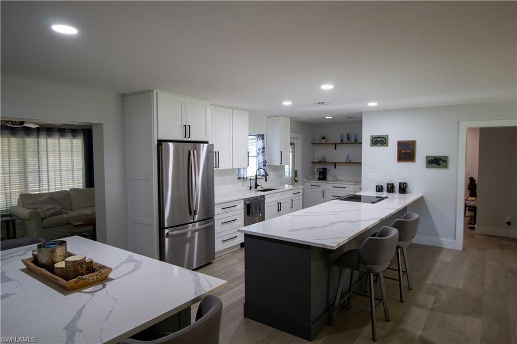 1280 Morningside Drive Naples, FL 34103 - Photo 9 of 35 a kitchen with a refrigerator and a stove top open
