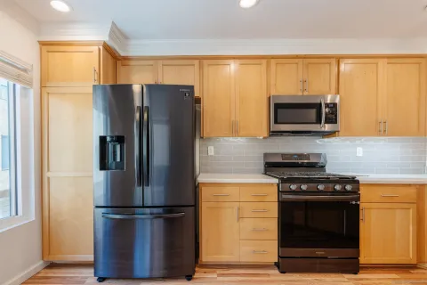 a kitchen with stainless steel appliances granite countertop a refrigerator stove and microwave