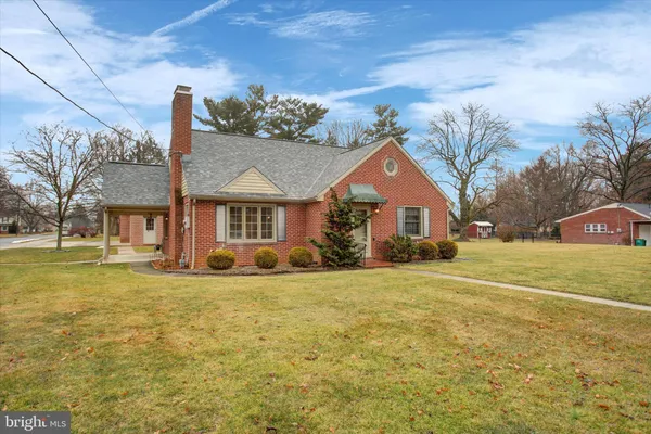 a front view of a house with a garden and tree