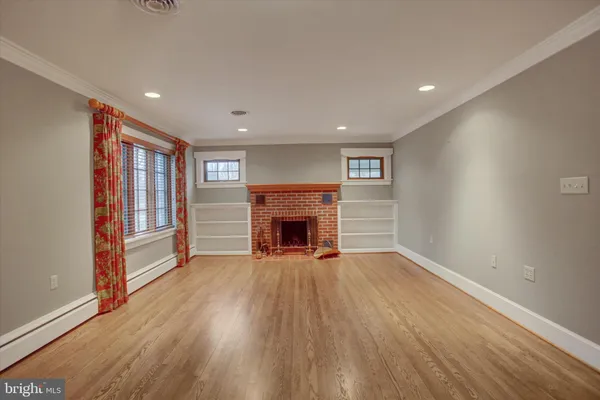 wooden floor fireplace and windows in an empty room