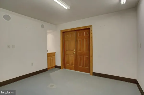 a view of a hall with wooden floor and a ceiling fan