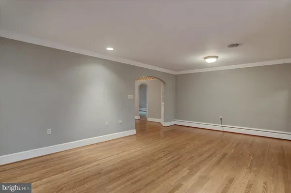 a view of a room with wooden floor chandelier and windows