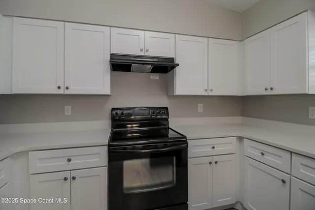 a kitchen with wooden floors and white cabinets