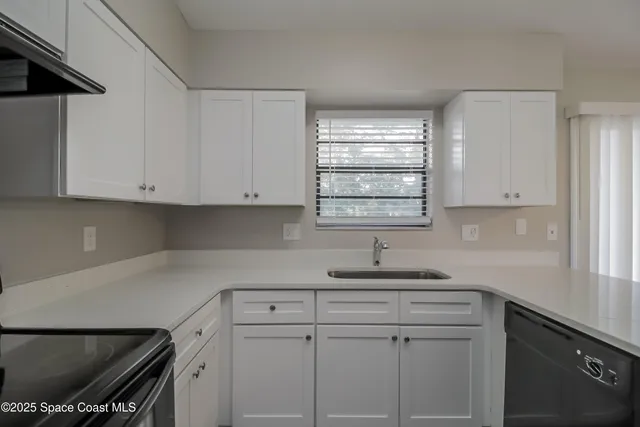 a kitchen with white cabinets and appliances