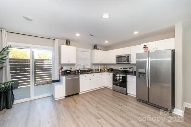 a kitchen with a refrigerator a sink and a stove top oven