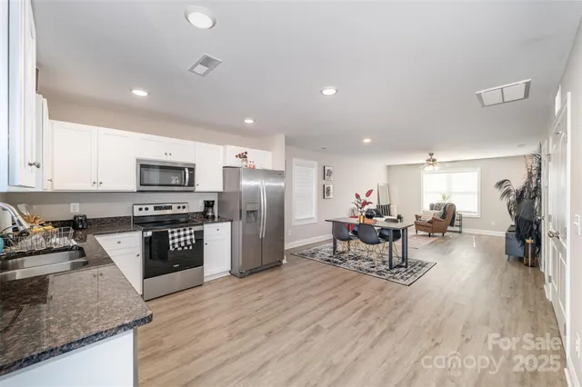 a kitchen with stainless steel appliances granite countertop a refrigerator stove microwave and sink