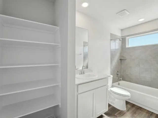 a view of an empty room with window and closet area