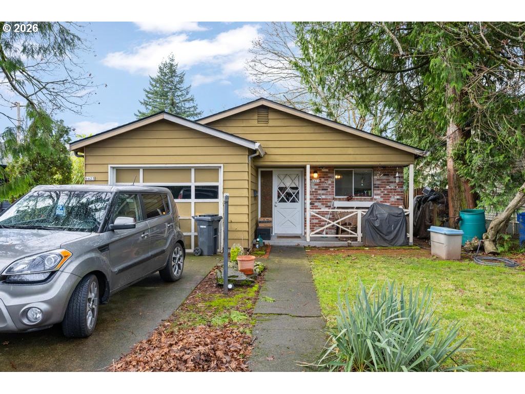 6421 Southeast 58th Avenue Portland, OR 97206 - Photo 1 of 14 a front view of a house with a garden and trees